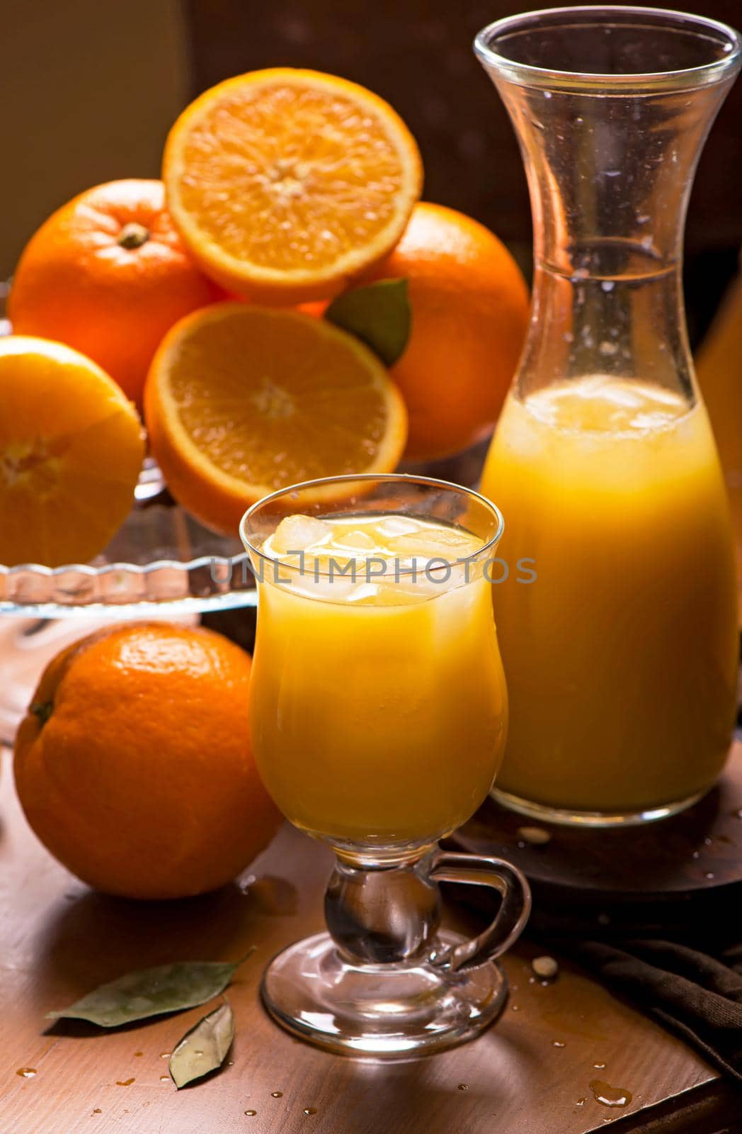 glass of fresh orange juice with fresh fruits on wooden table