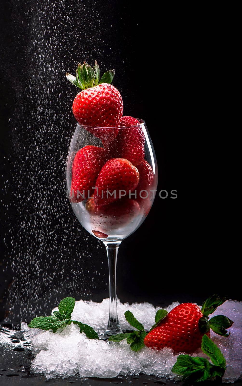 Strawberries in glass on the black background by aprilphoto