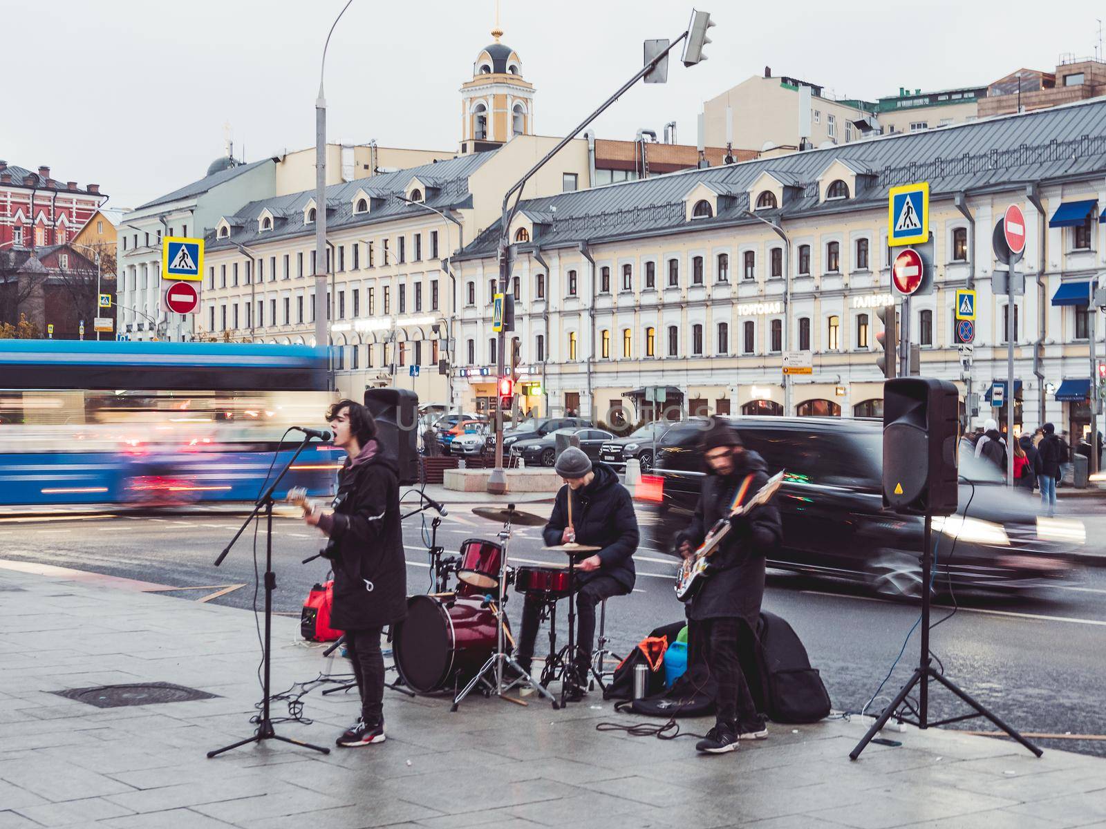 MOSCOW, RUSSIA - November 14, 2020. Street musicians play in the town square. Youth rock band on background of evening lights of capital. by aksenovko