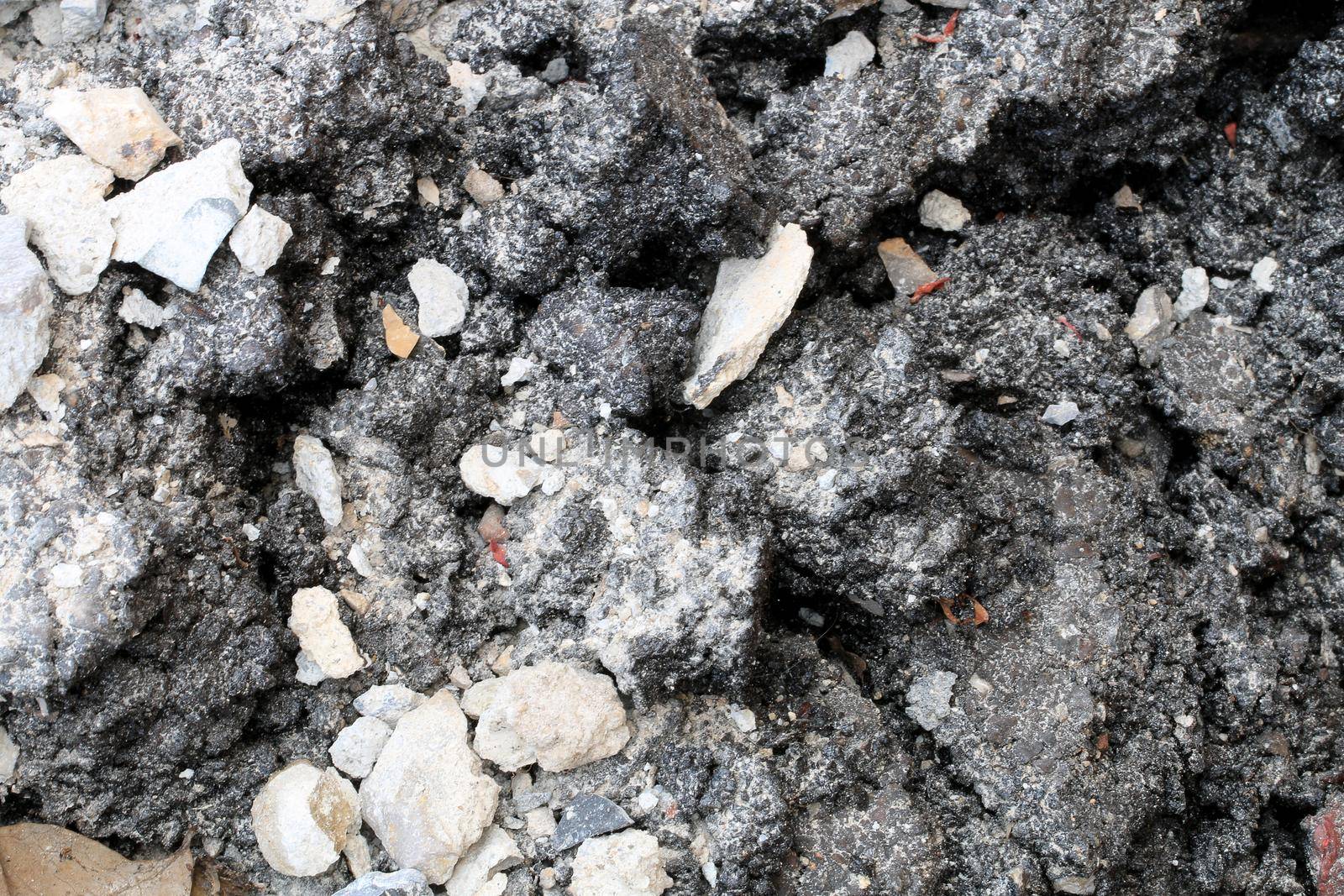 broken concrete floor at building construction site. cracked concrete texture background. Grey surface with cracks close up. A lot of pieces of splintered plaster. Abstract concept of split, dissent,