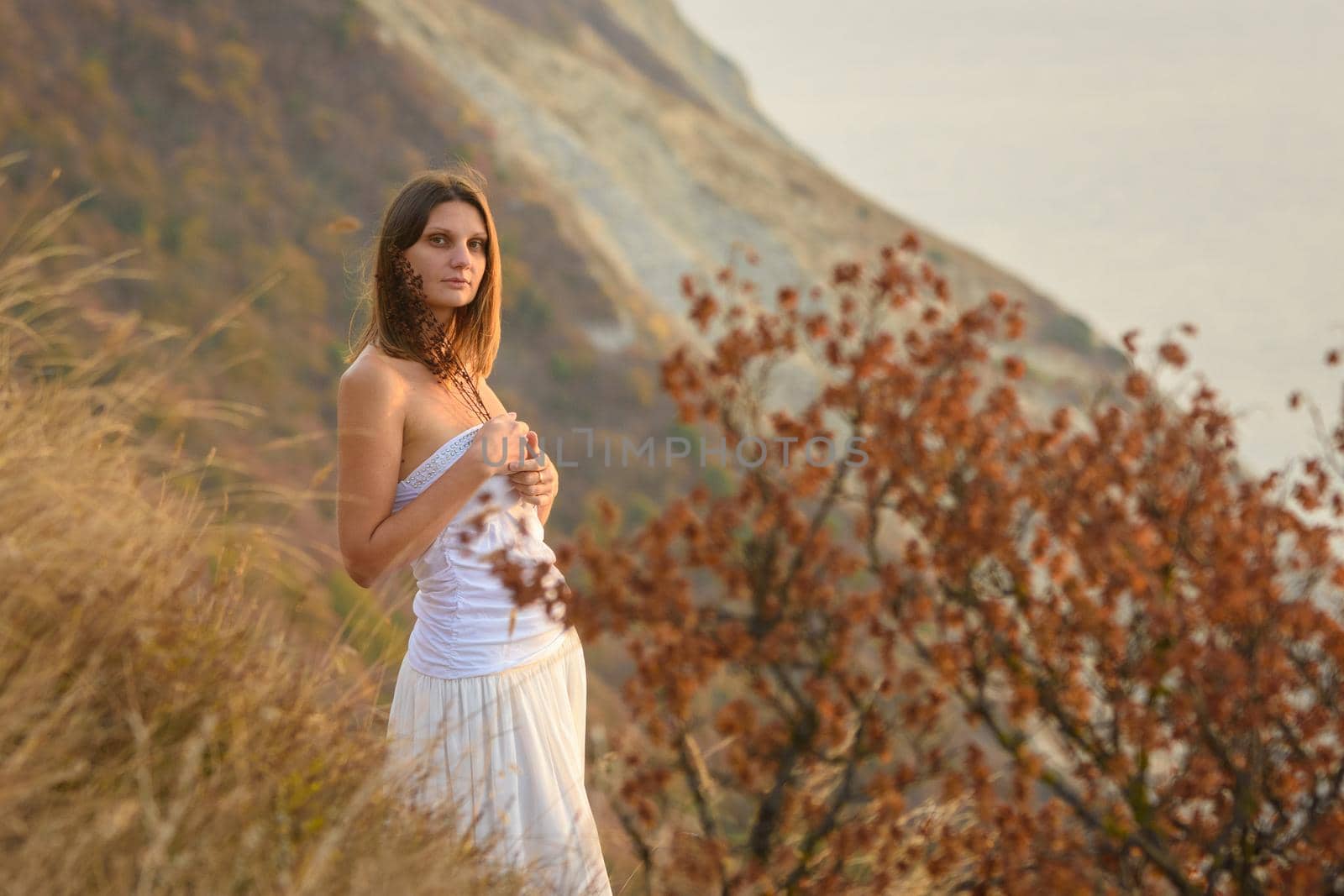 Beautiful girl with wild flowers on the background of a beautiful landscape by Madhourse