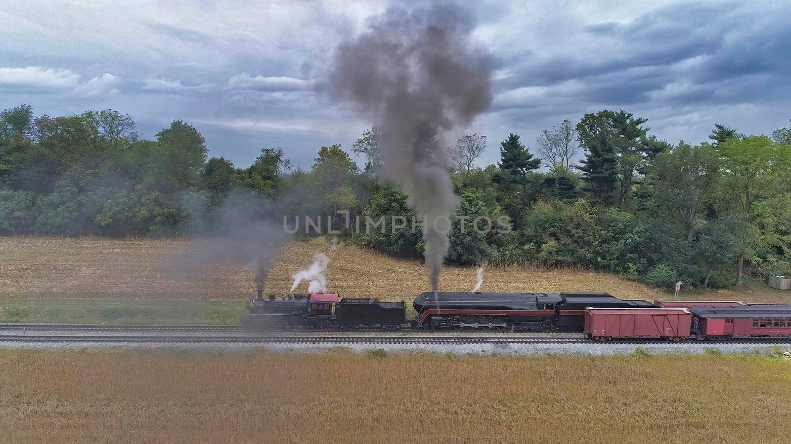 Aerial View of 2 Restored Antique Steam Engines and Double Heading and Steaming Up at a Small Rail Road Station