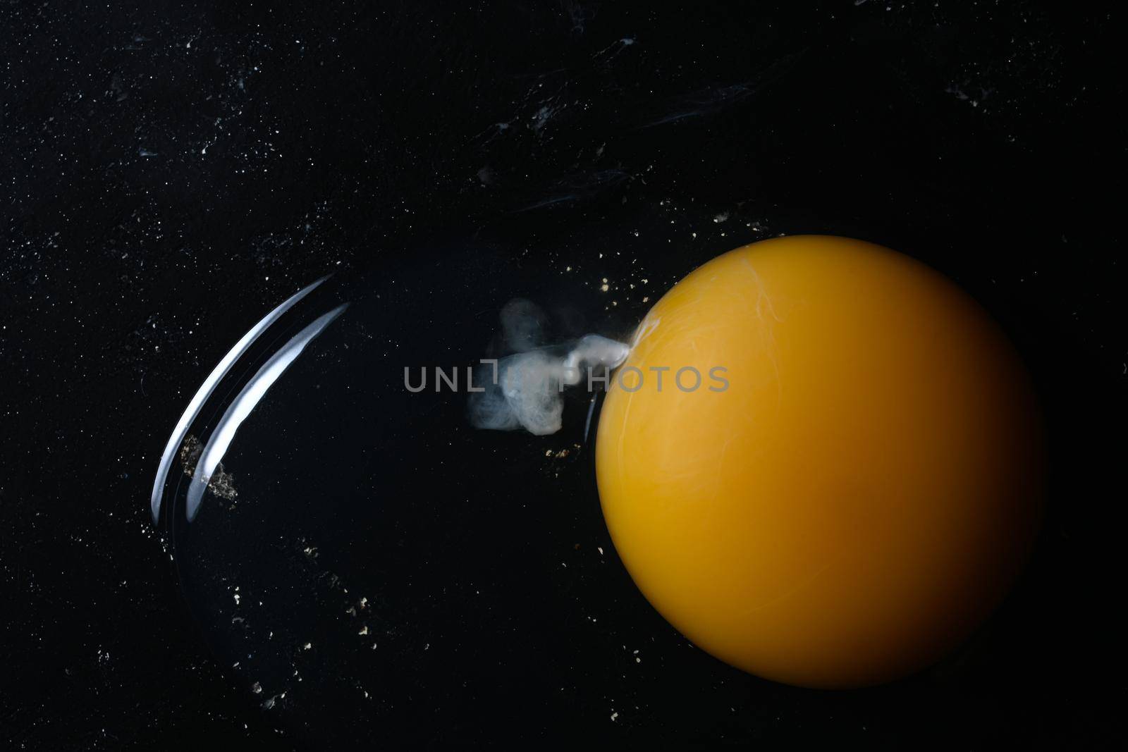 Broken Raw Egg Yolk on Dark Stone Background.