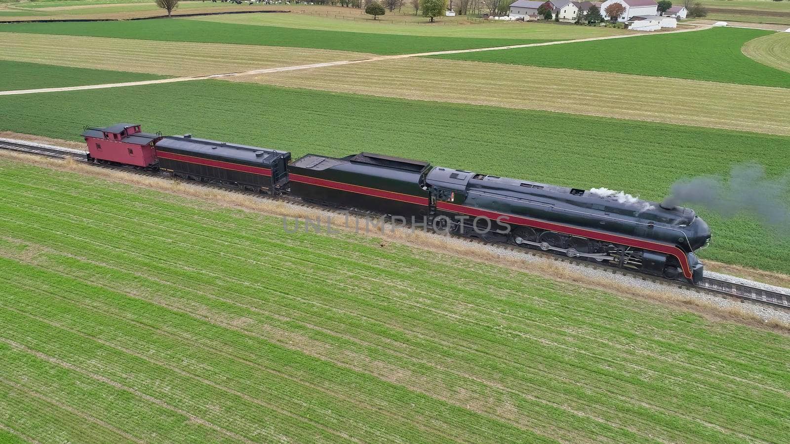 Aerial View of a Restored Antique Steam Locomotive Pulling a Caboose on a Sunny Fall Day