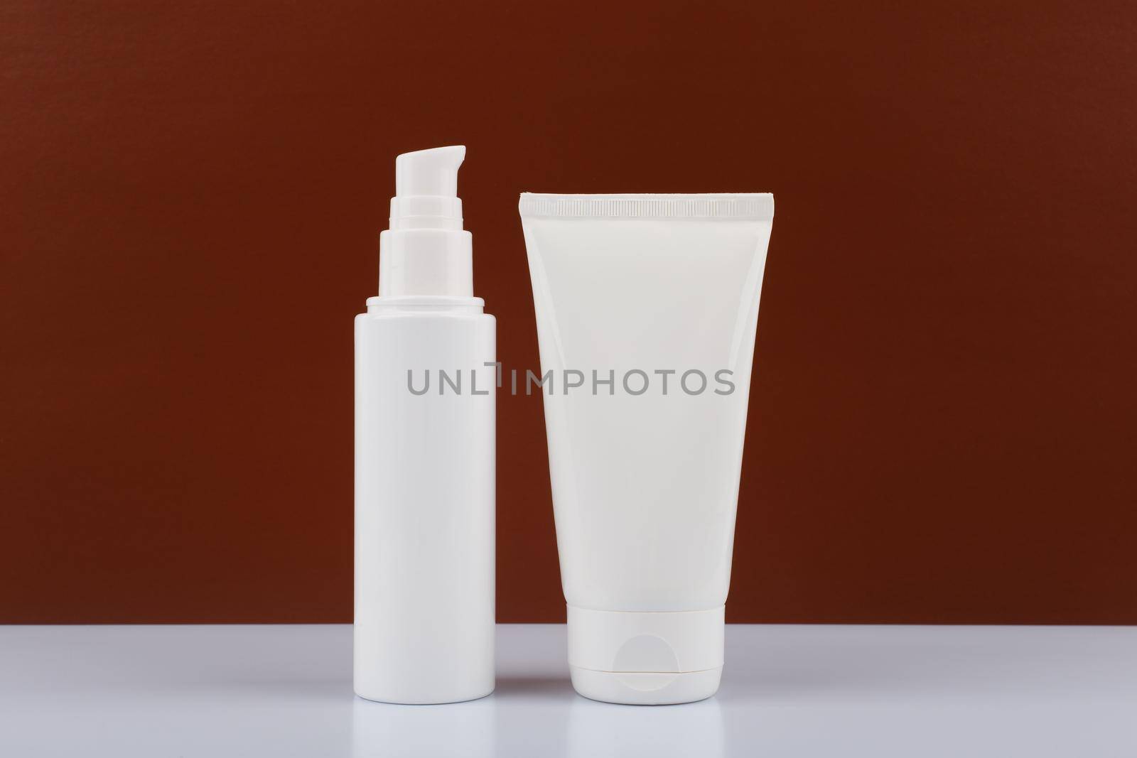 Two white cream tubes on white table against dark brown background. Concept of male skincare with copy space by Senorina_Irina