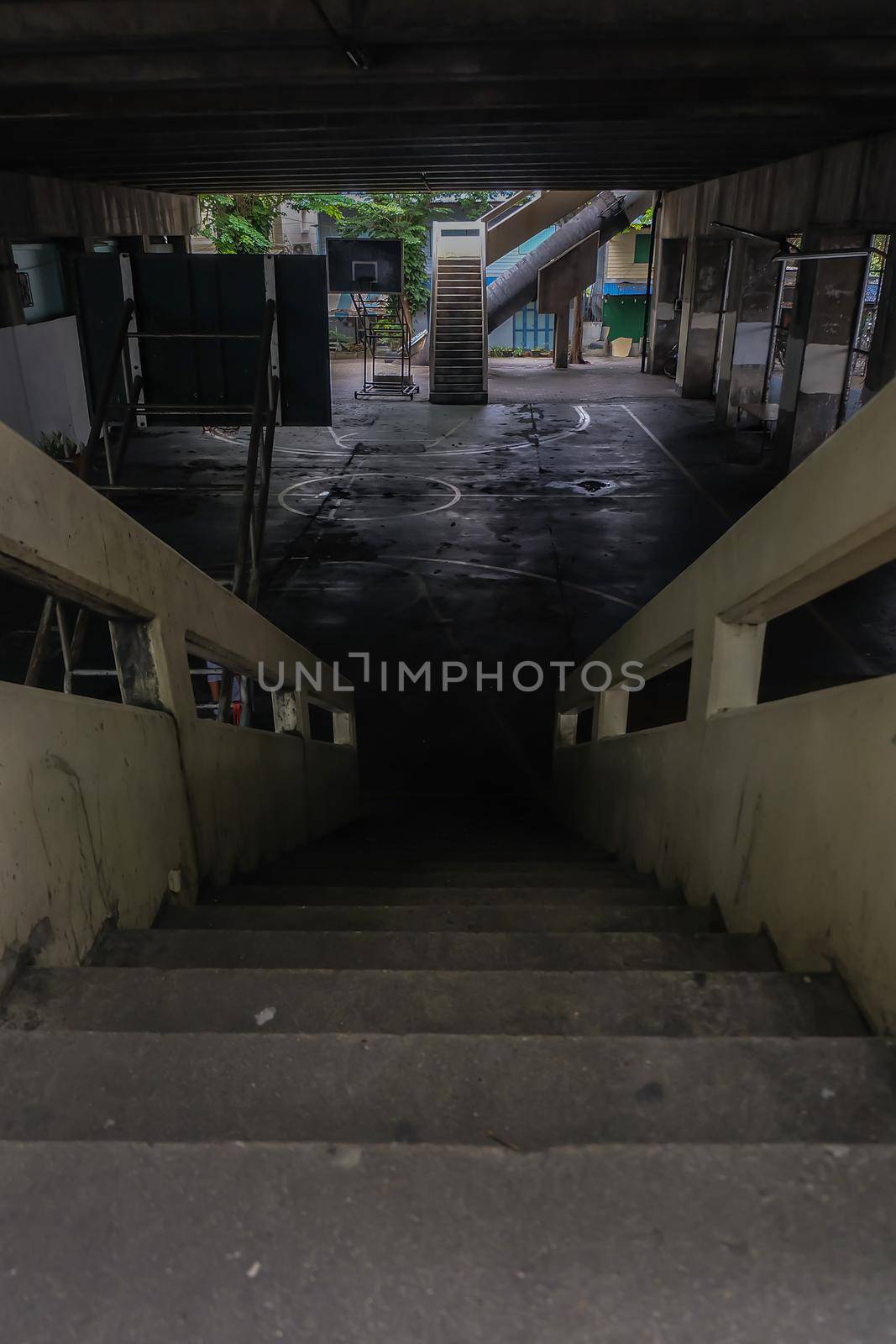 View from the top of the old cement stairs leading down to the community basketball court under the bridge. Focus and blur.