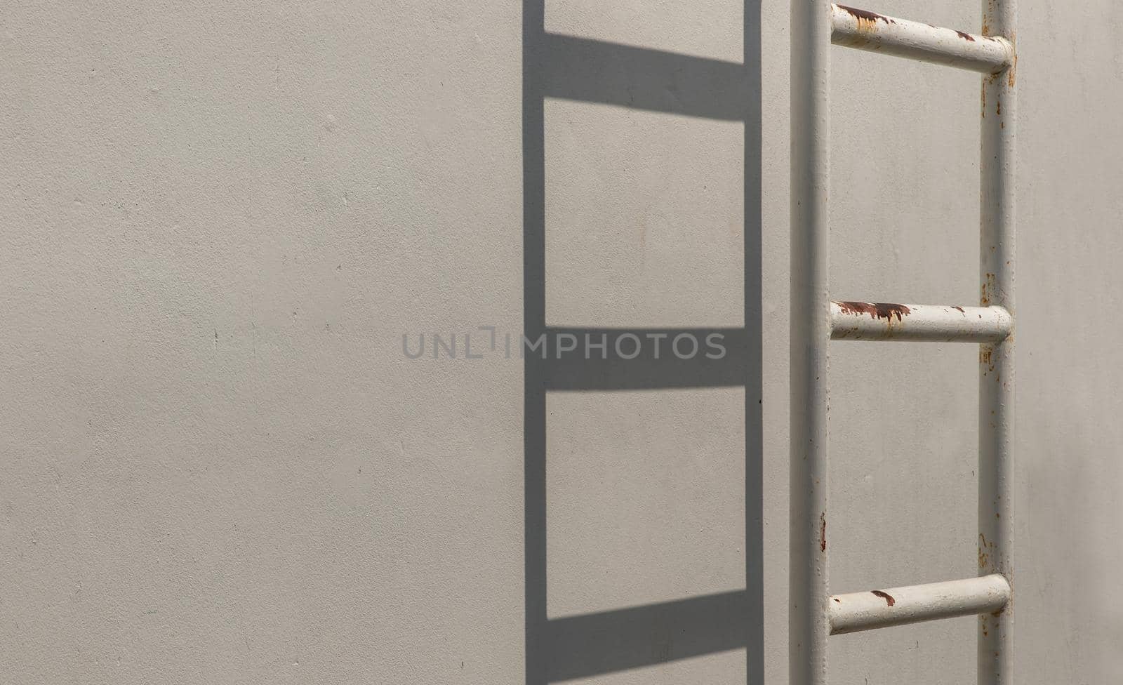 White metal fire escape attached to a wall and leading to the roof of a building. Copy space, Selective focus.