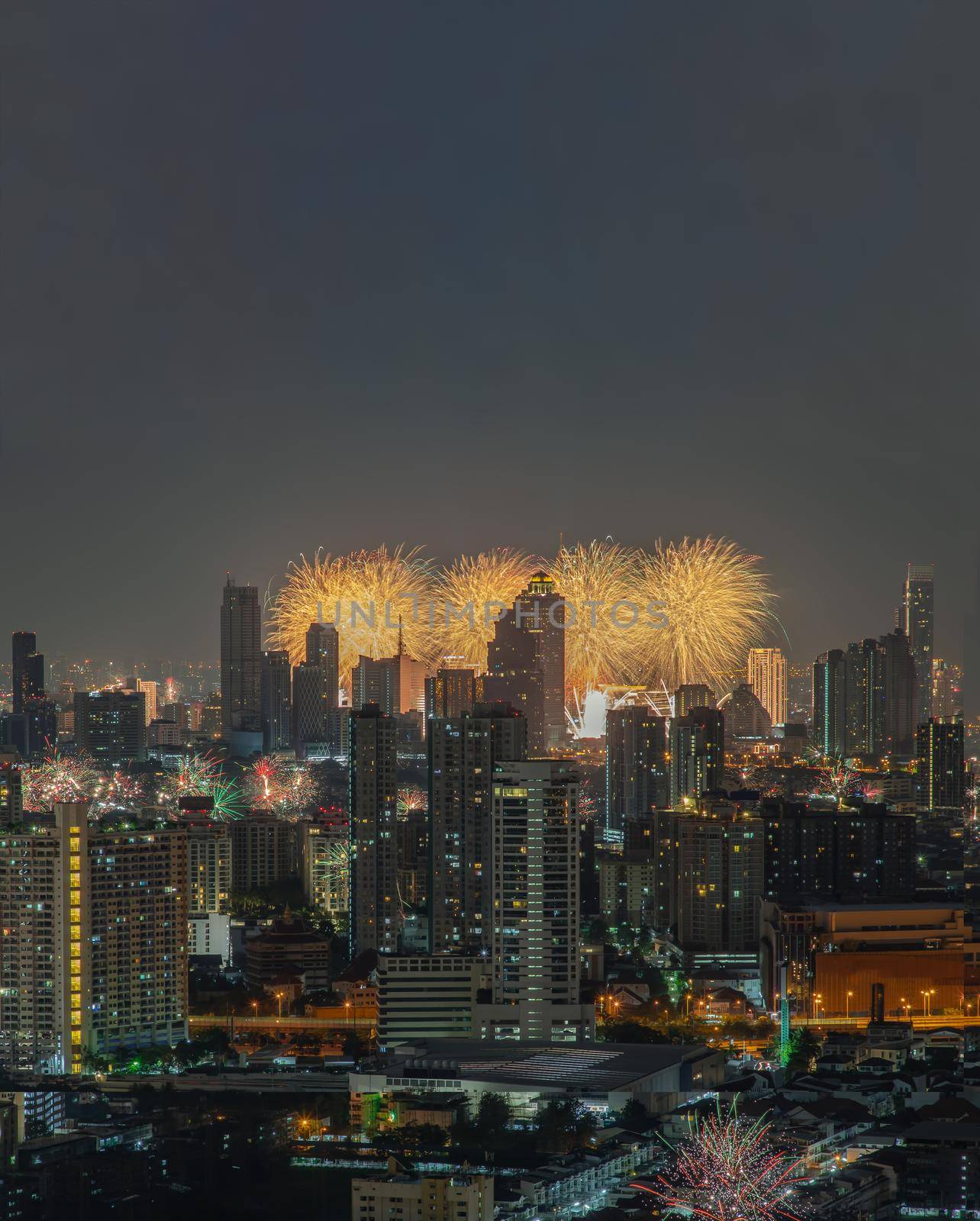 Colorful Firework with cityscape night light view of Bangkok skyline at twilight time. New Year celebration fireworks, Bangkok city,Thailand Fireworks light up to sky at Christmas & New Year festival with free space for text. No focus, specifically.