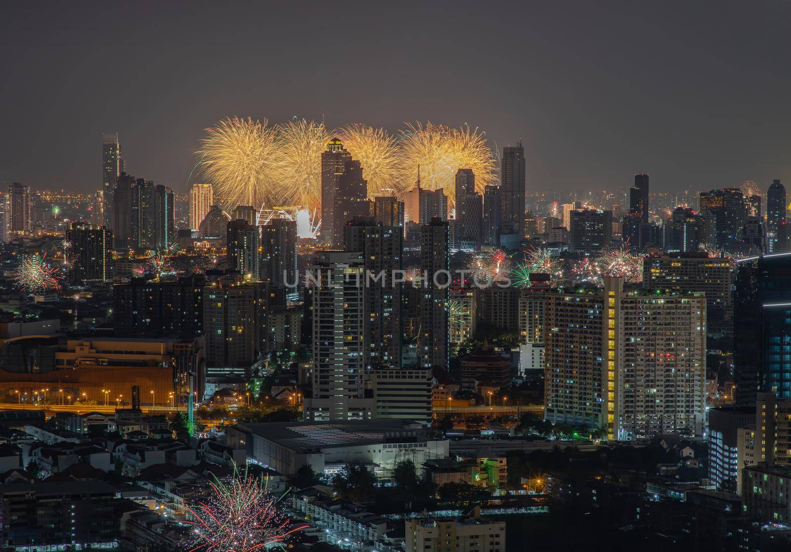 Colorful Firework with cityscape night light view of Bangkok skyline at twilight time. New Year celebration fireworks, Bangkok city,Thailand Fireworks light up to sky at Christmas & New Year festival with free space for text. No focus, specifically.