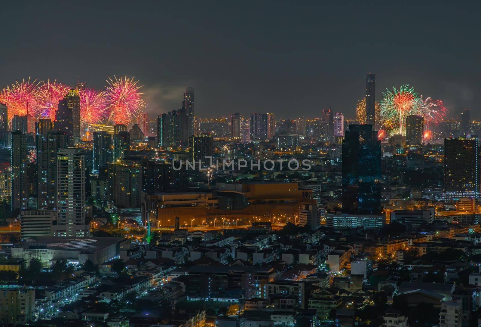 Colorful Firework with cityscape night light view of Bangkok skyline at twilight time. New Year celebration fireworks, Bangkok city,Thailand Fireworks light up to sky at Christmas & New Year festival with free space for text. No focus, specifically.