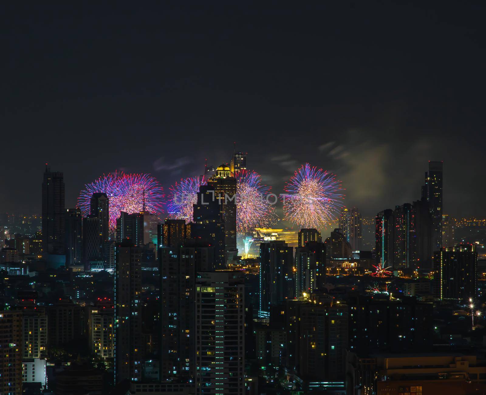 Colorful Firework with cityscape night light view of Bangkok skyline at twilight time. New Year celebration fireworks, Bangkok city,Thailand Fireworks light up to sky at Christmas & New Year festival with free space for text. No focus, specifically.
