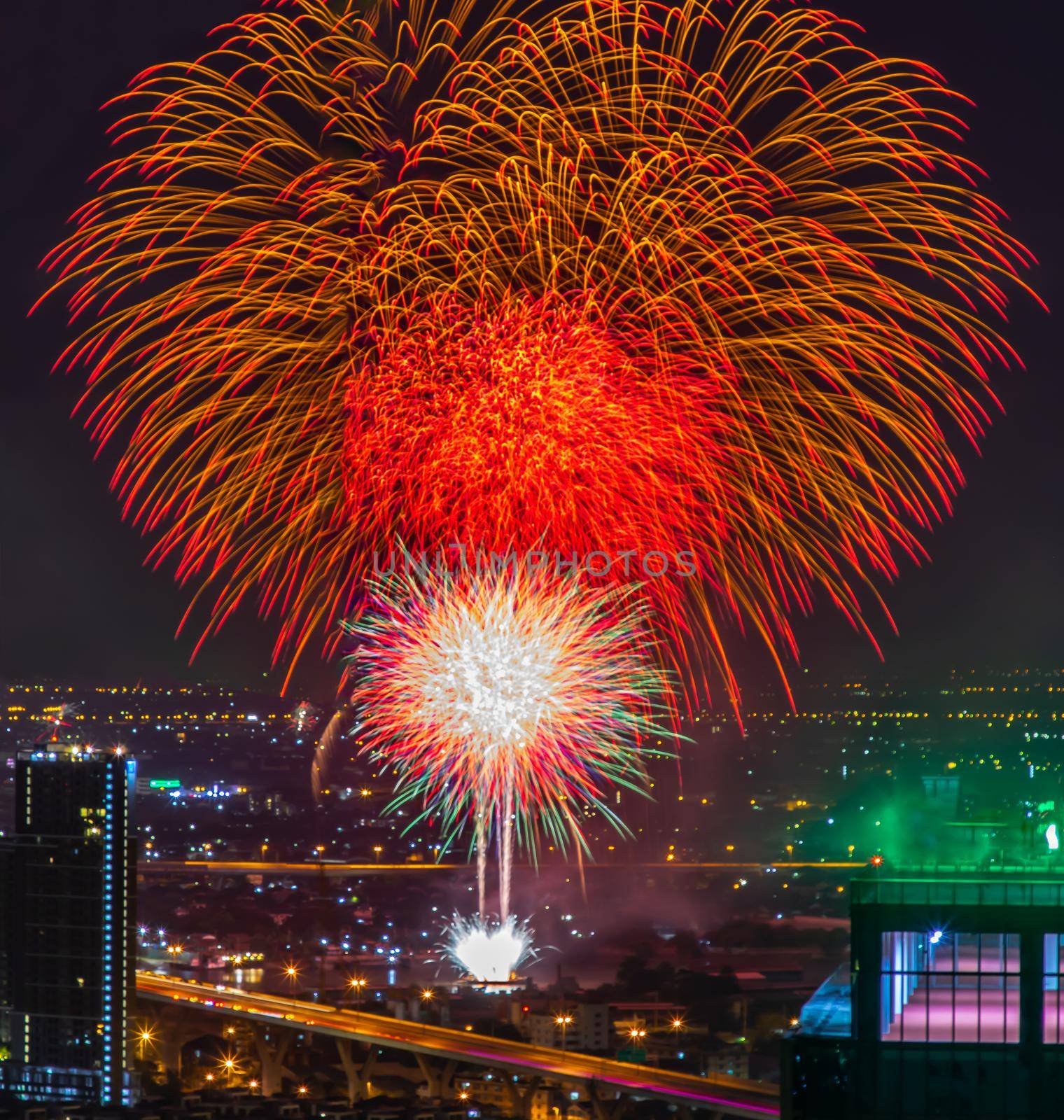 Colorful Firework with cityscape night light view of Bangkok skyline at twilight time. New Year celebration fireworks, Bangkok city,Thailand Fireworks light up to sky at Christmas & New Year festival with free space for text. No focus, specifically.