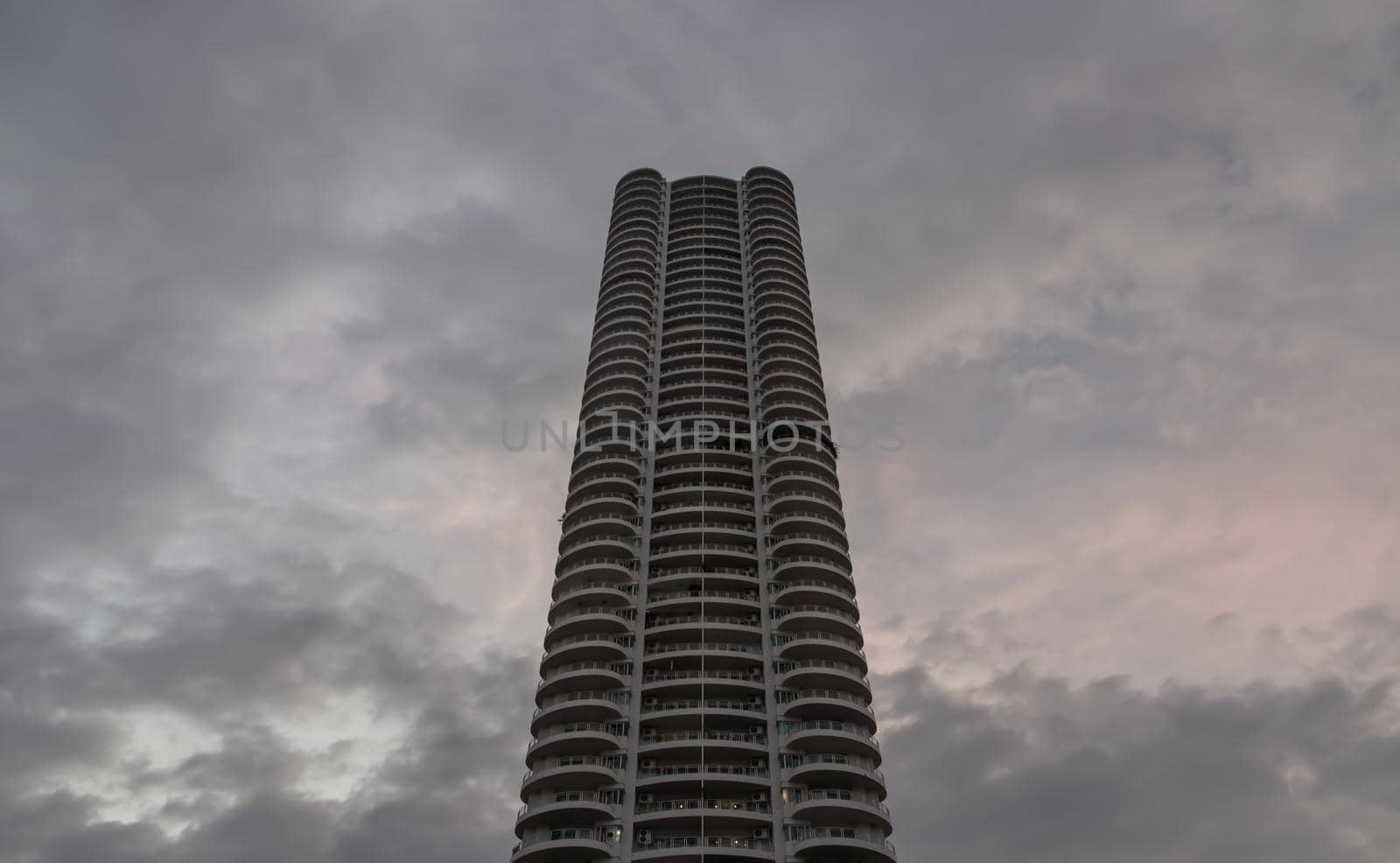 Bangkok, Thailand - 04 Jan 2021 : Low angle looking up at Condominium building with repeating structure and clouds background. Dark tone, No focus, specifically.