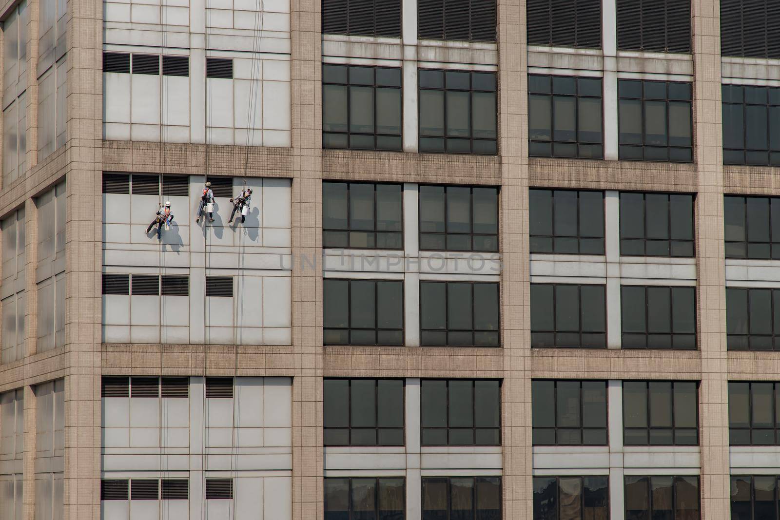 Group of workers cleaning windows service on high rise office building. Selective focus.
