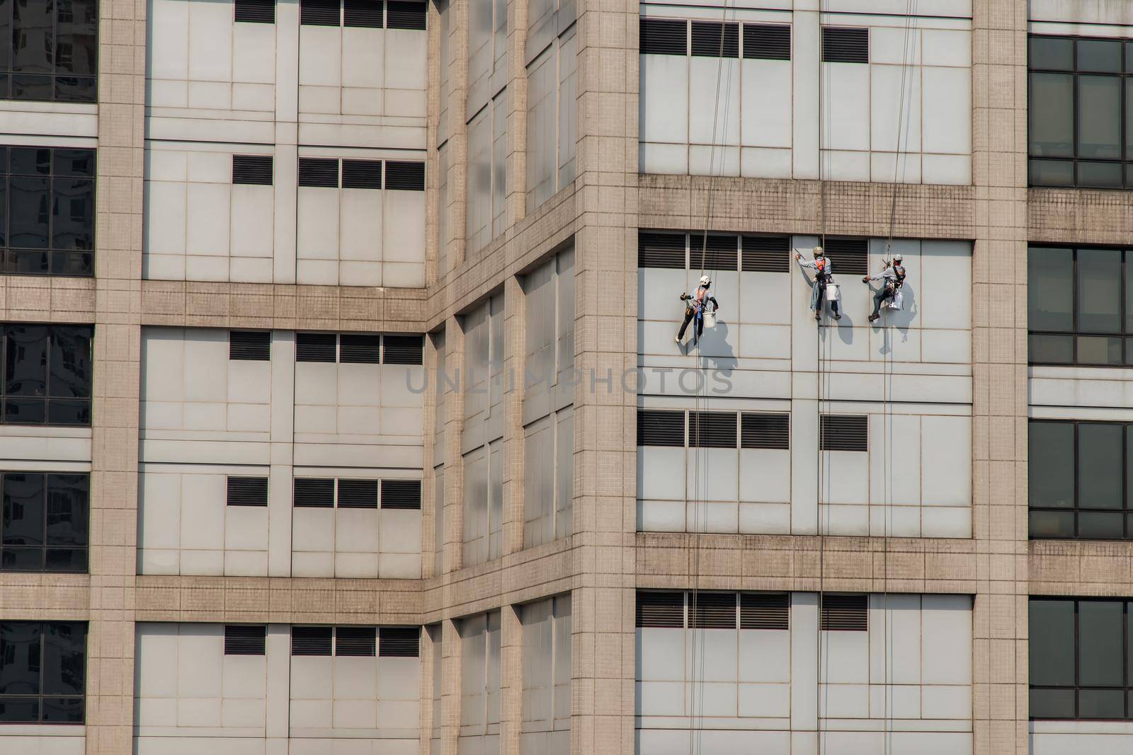 Group of workers cleaning windows service on high rise office building. Selective focus.