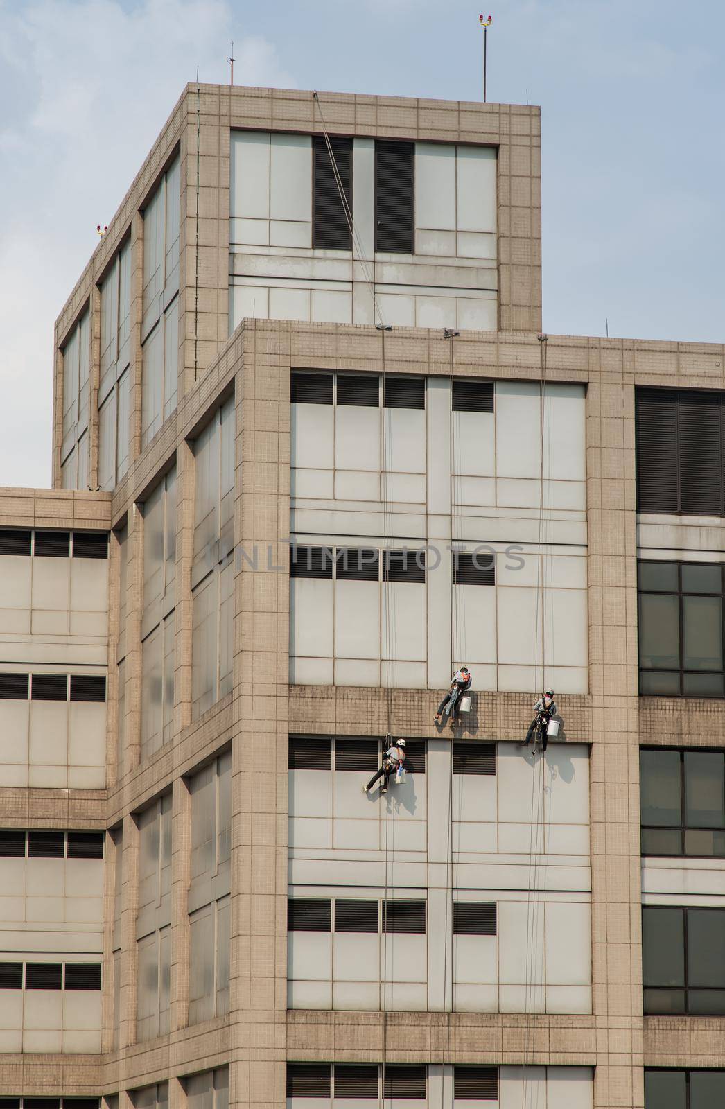 Group of workers cleaning windows service on high rise office building. Selective focus.