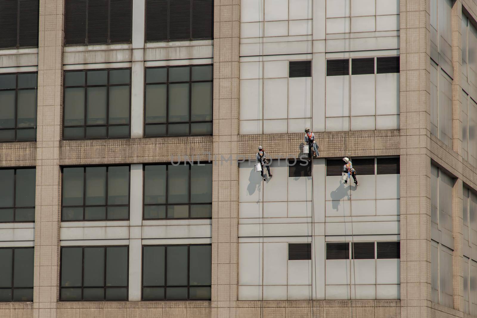 Group of workers cleaning windows service on high rise office building. Selective focus.