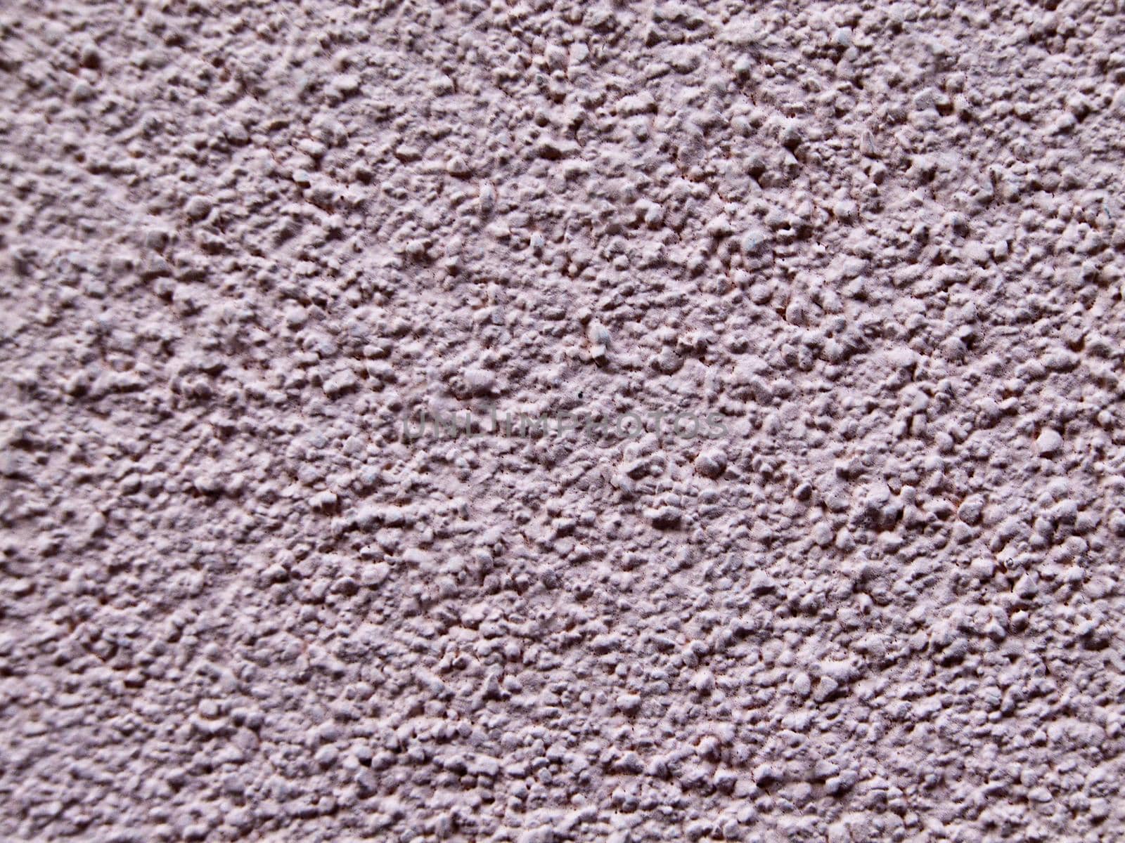 The textured rough surface of the plastered wall of the house is lilac in color.Texture or background