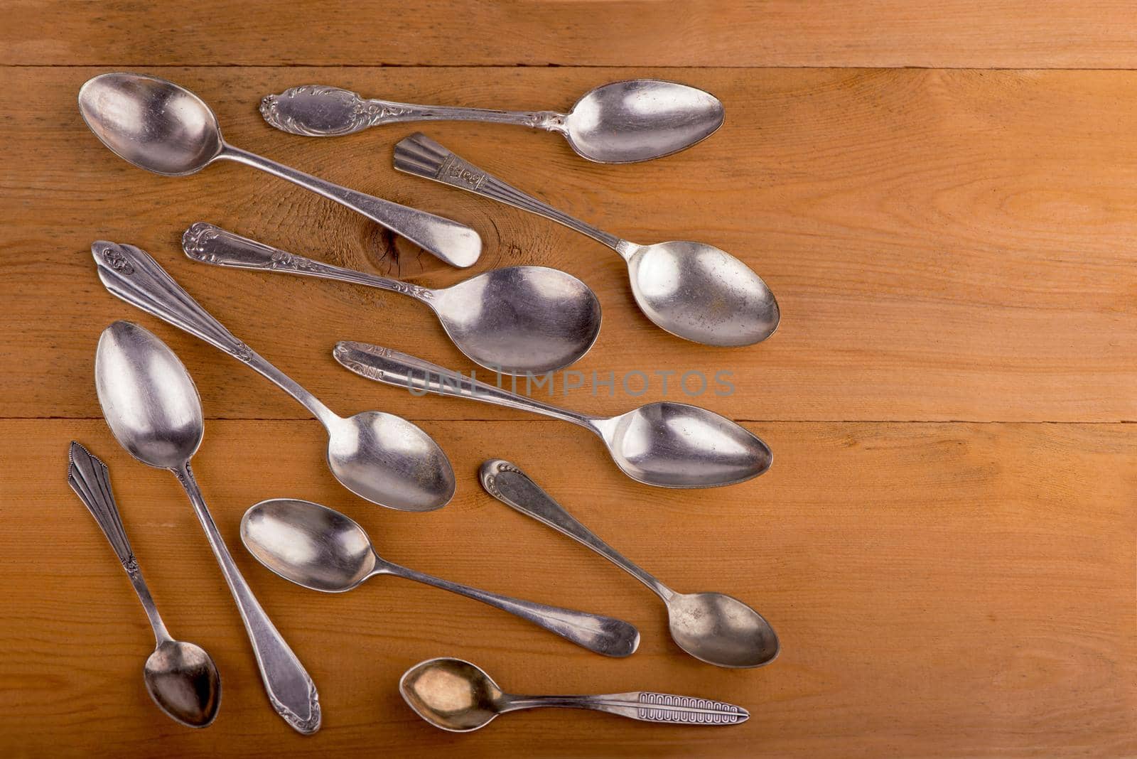 Vintage cutlery. different spoons on wooden background. Antique silverware. Retro. by aprilphoto