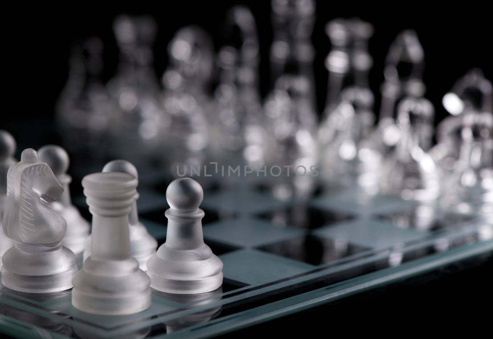 glass chess pieces on board in dark