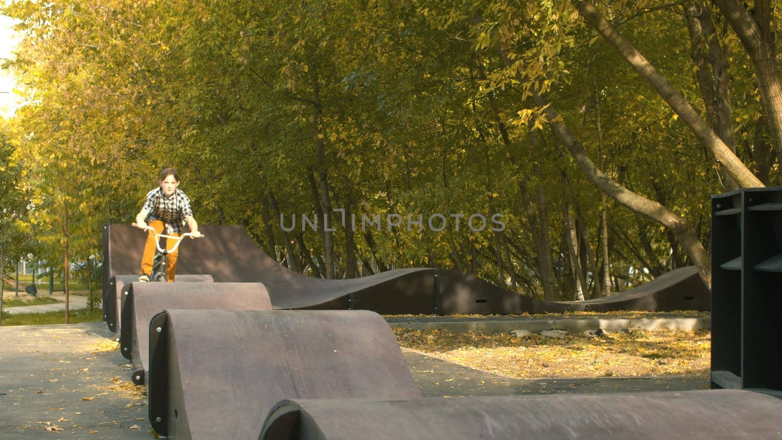 Young boy, biker riding on the pump track in the park at sunny day. Childrens sport and healthy lifestyle concept