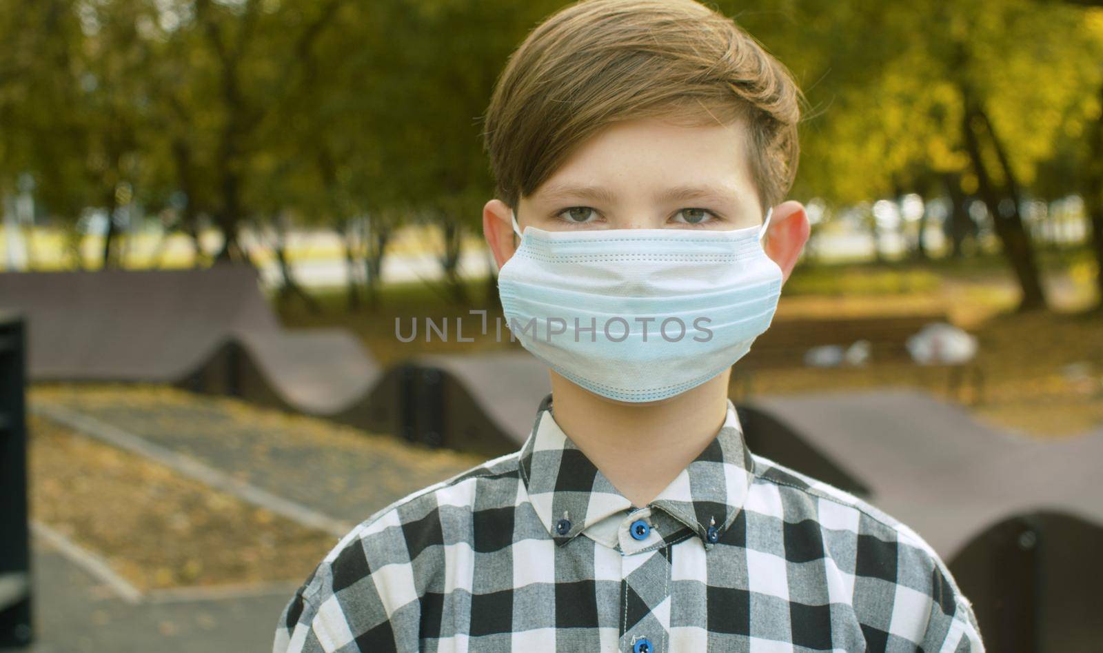 Portrait of teen boy wearing a medical mask. Protection against a viral epidemic in the city. Health medical care and safety, flu virus, pandemic