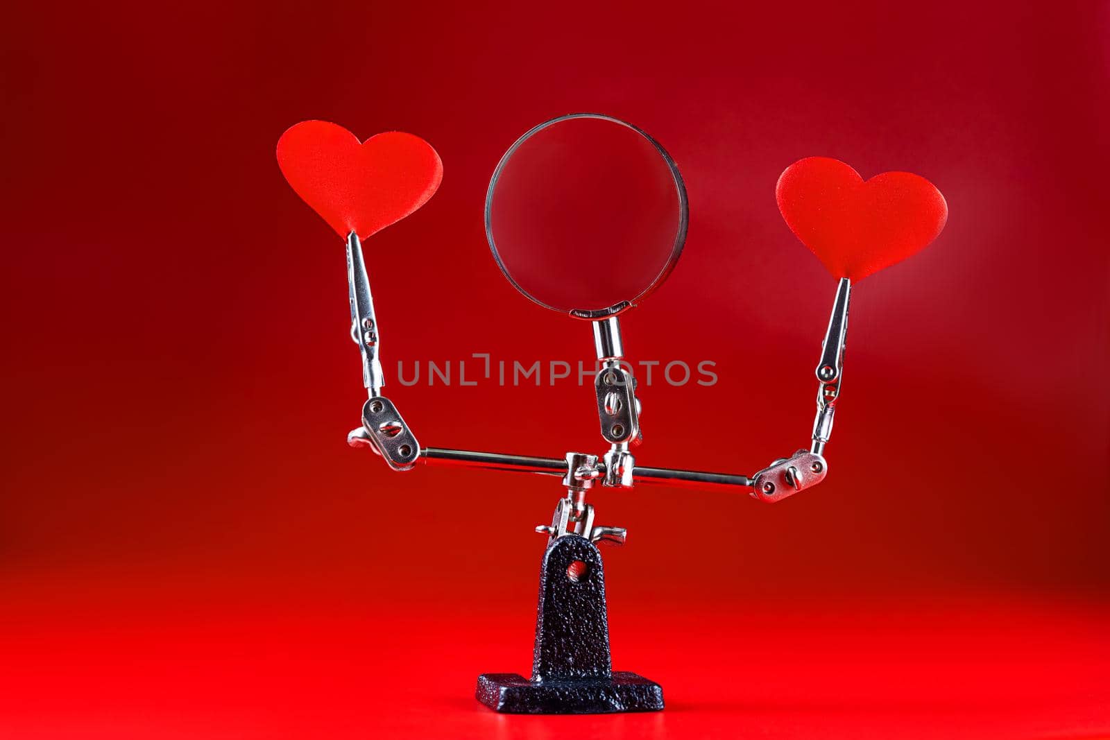 Abstract Valentines Day background with engineering tool third hand holding hearts on red background and copyspace