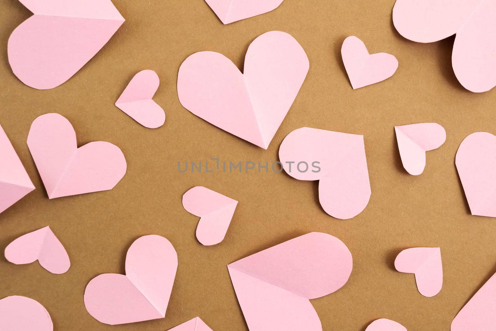 Valentine's Day background. Pink hearts on a craft background. Valentine's Day concept. Layout for postcards and congratulations. Flat lay, top view, copy space by Alla_Morozova93