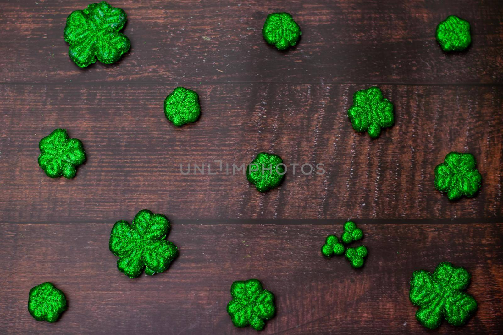 Glitter Covered Four Leaf Clovers in a Pattern on a Wood Background by bju12290