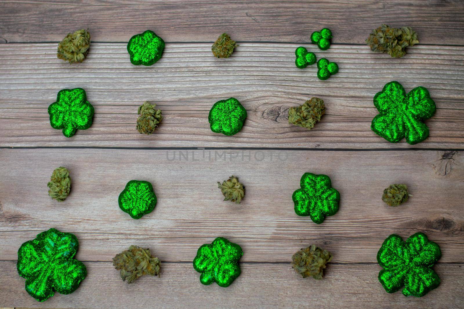 Cannabis Nugs and Glitter Covered Four Leaf Clovers on a Wood Background by bju12290