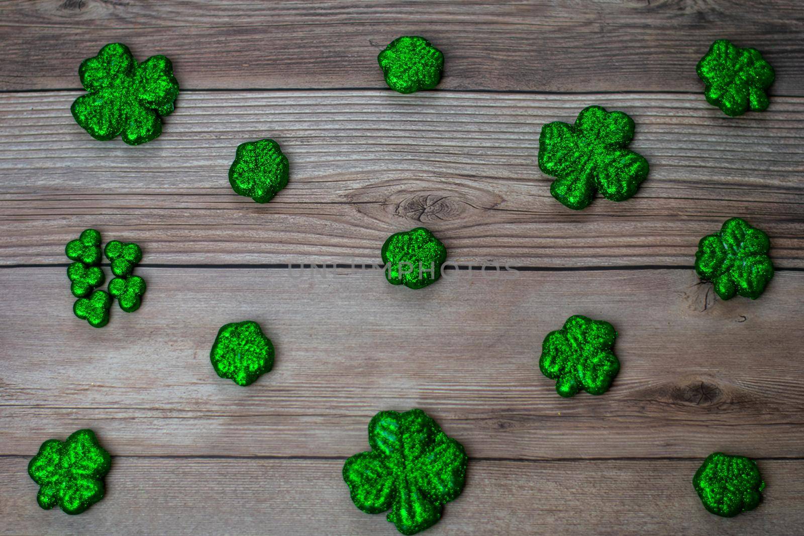 Glitter Covered Four Leaf Clovers in a Pattern on a Wood Background by bju12290