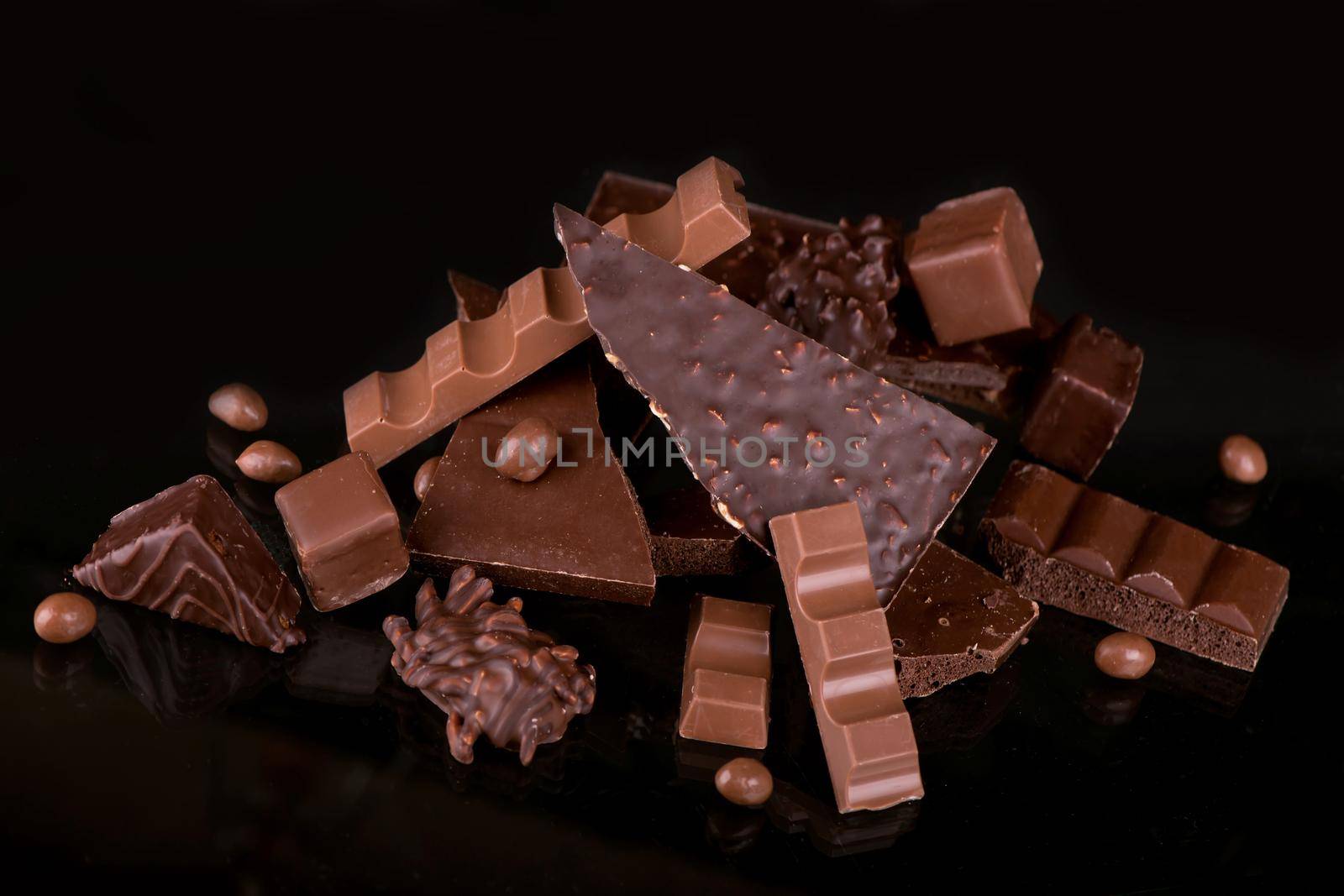 Broken chocolate pieces and cocoa powder on wooden background. by aprilphoto