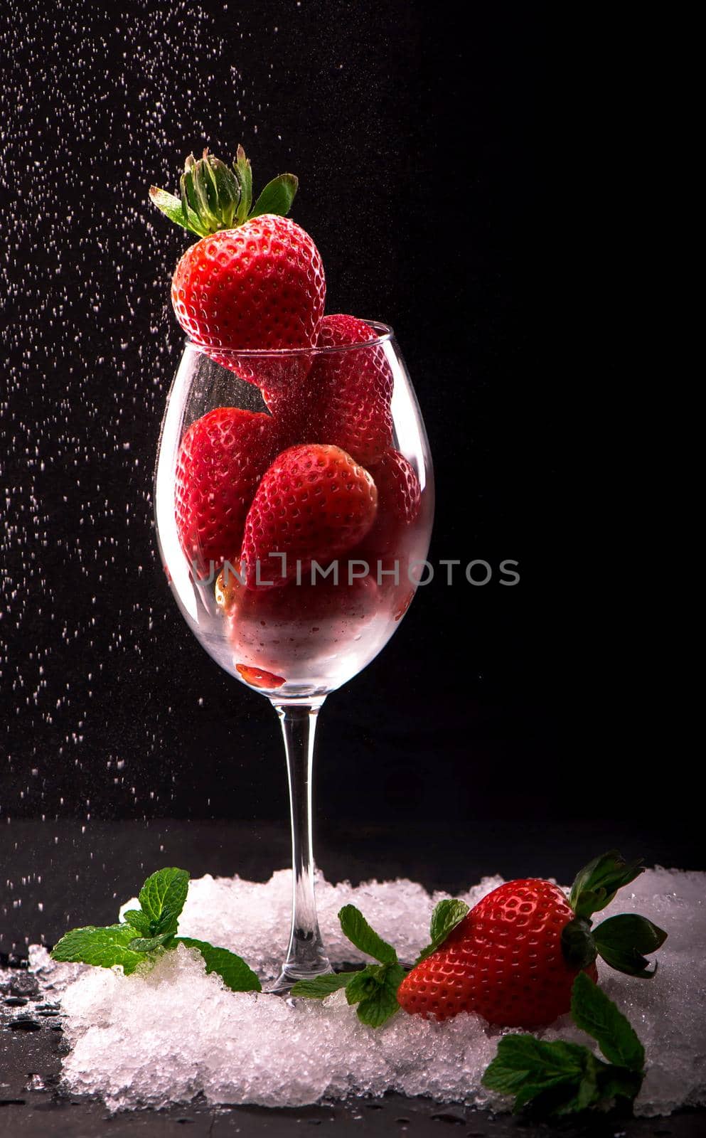 Strawberries in glass on black background