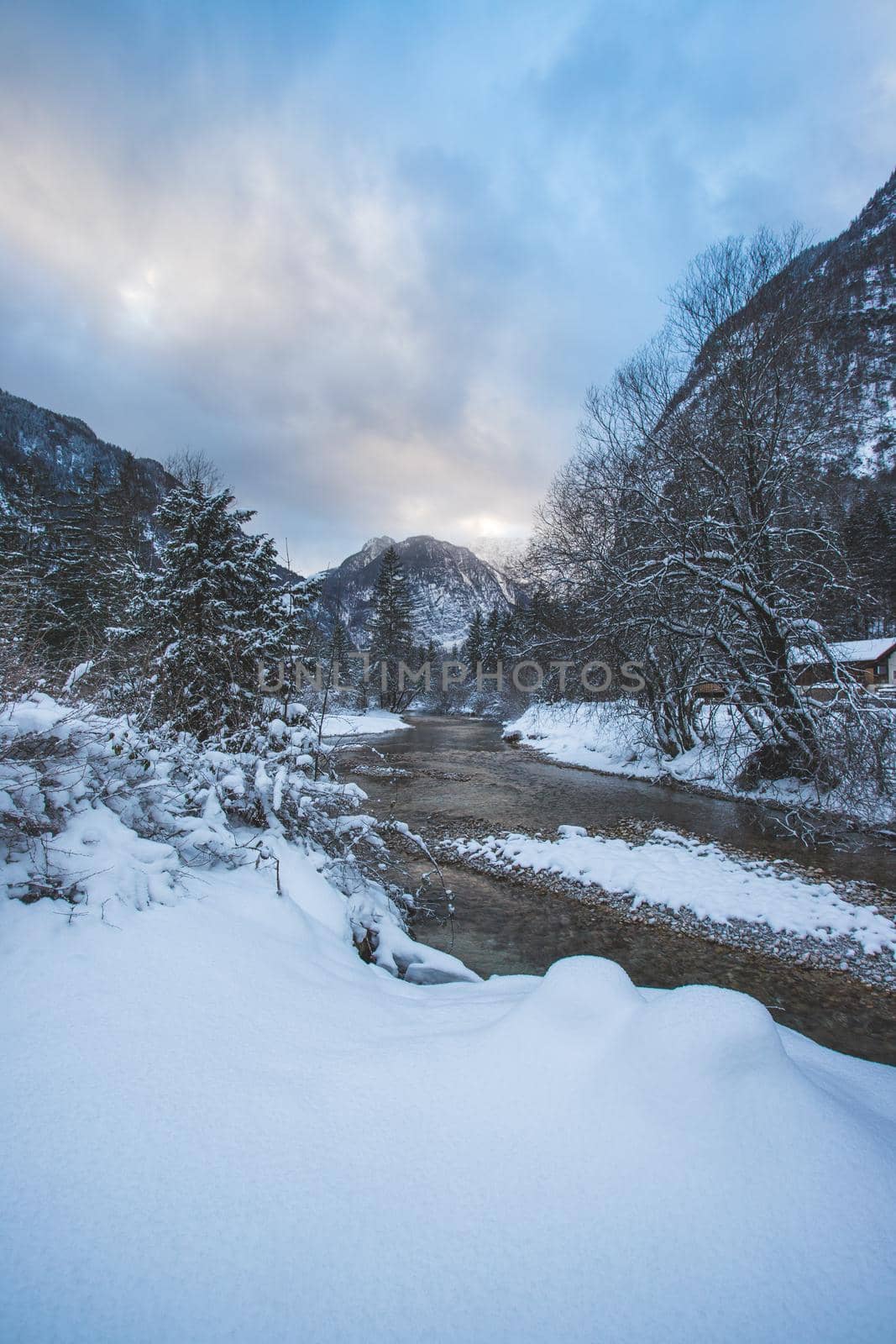 Winter landscape with frosty river, snowy trees and mountains. Buntautal and Bluntausee. by Daxenbichler