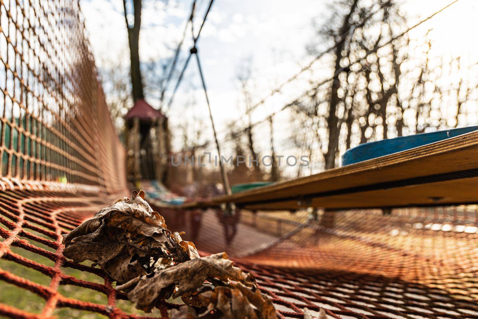 Few dry leafs lie on net in rope park for kids by Wierzchu