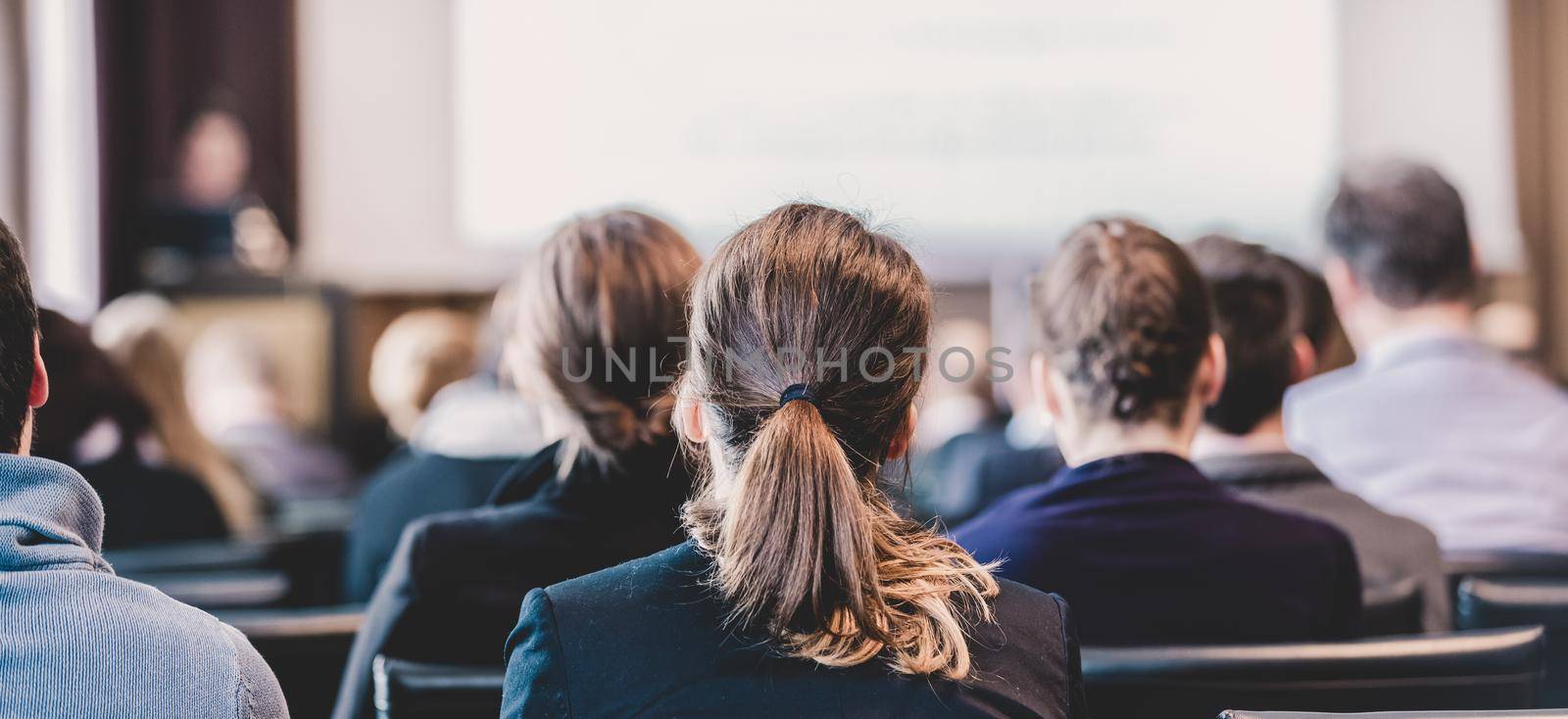 Speaker Giving a Talk at Business Meeting. Audience in the conference hall. Business and Entrepreneurship. Panoramic composition suitable for banners.