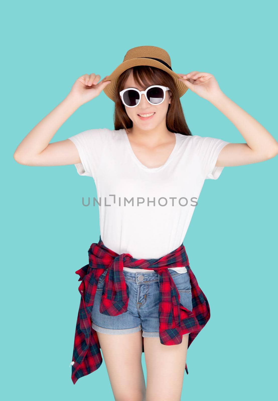 Beautiful portrait young asian woman wear sunglasses holding hat smile cheerful and enjoy travel summer trip holiday in vacation isolated blue background, tourist happy asia girl confident and excited. by nnudoo