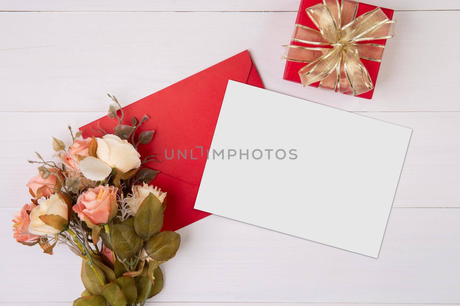 Valentine day, greeting card mockup and letter and flower on wooden table, postcard blank and gift box with romance on desk, present in anniversary and celebration, top view, holiday concept.