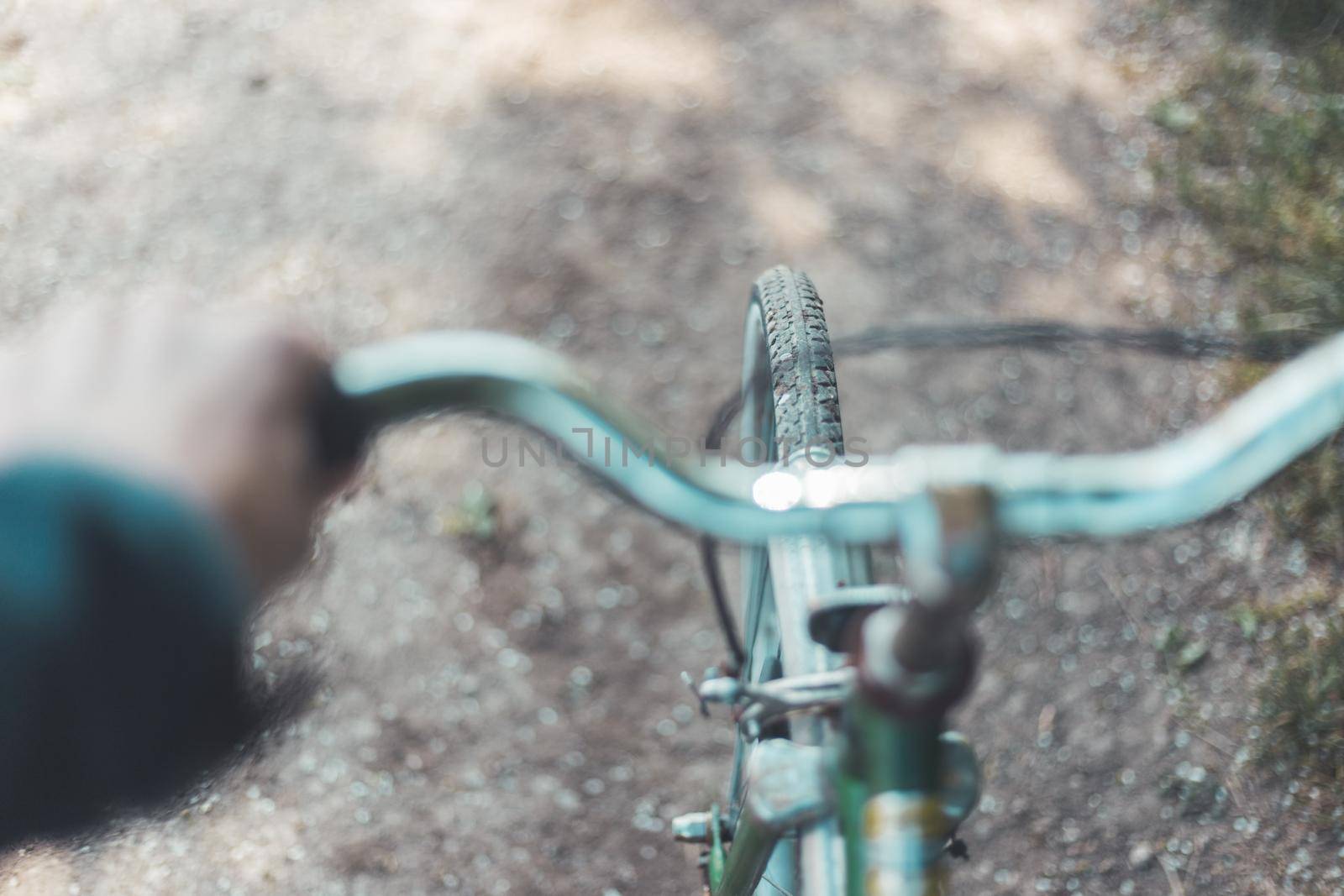 Close up picture of retro bike tire, blurry handlebar, summer day