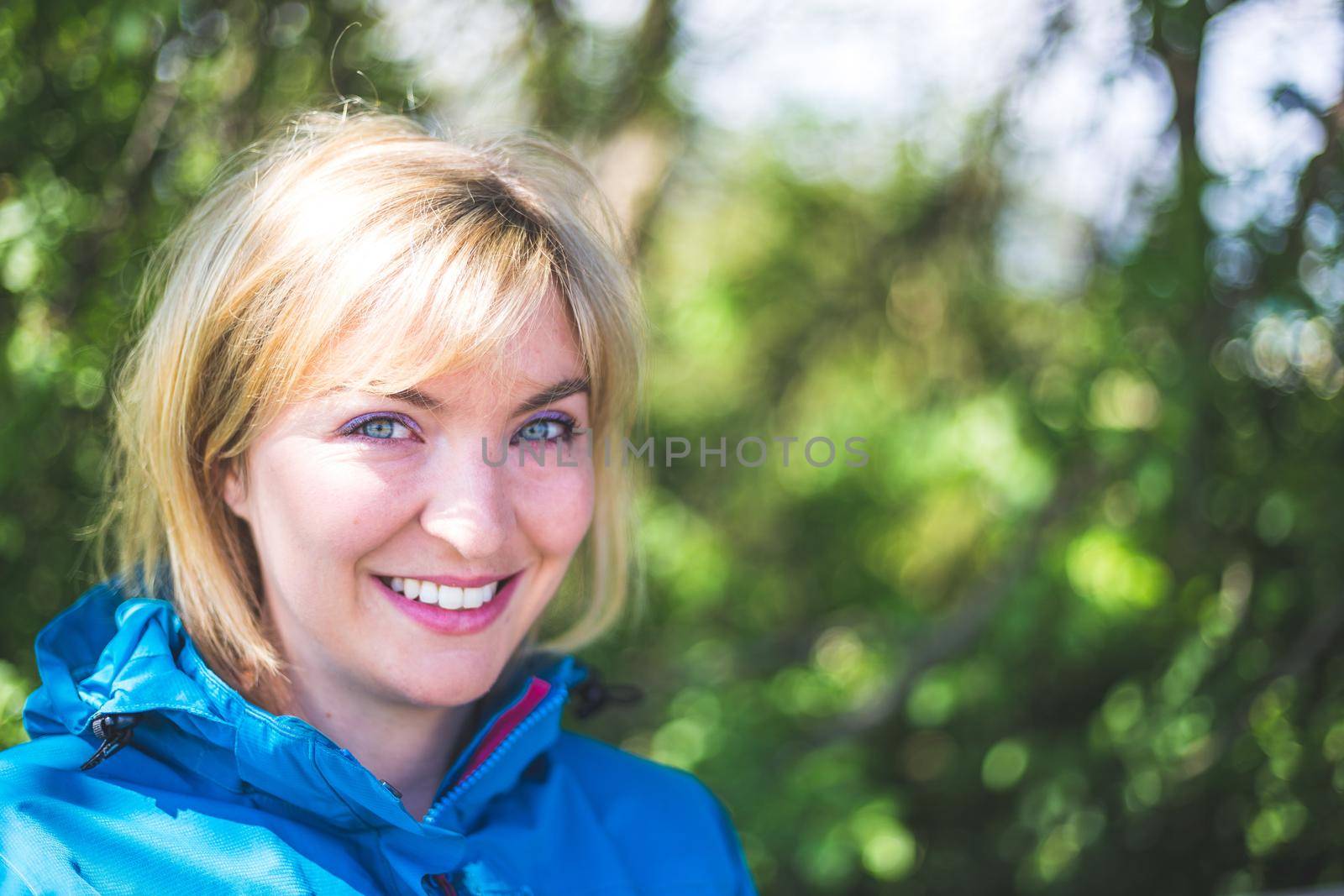 Portrait of attractive young girl outdoors, spring time, blurry green background