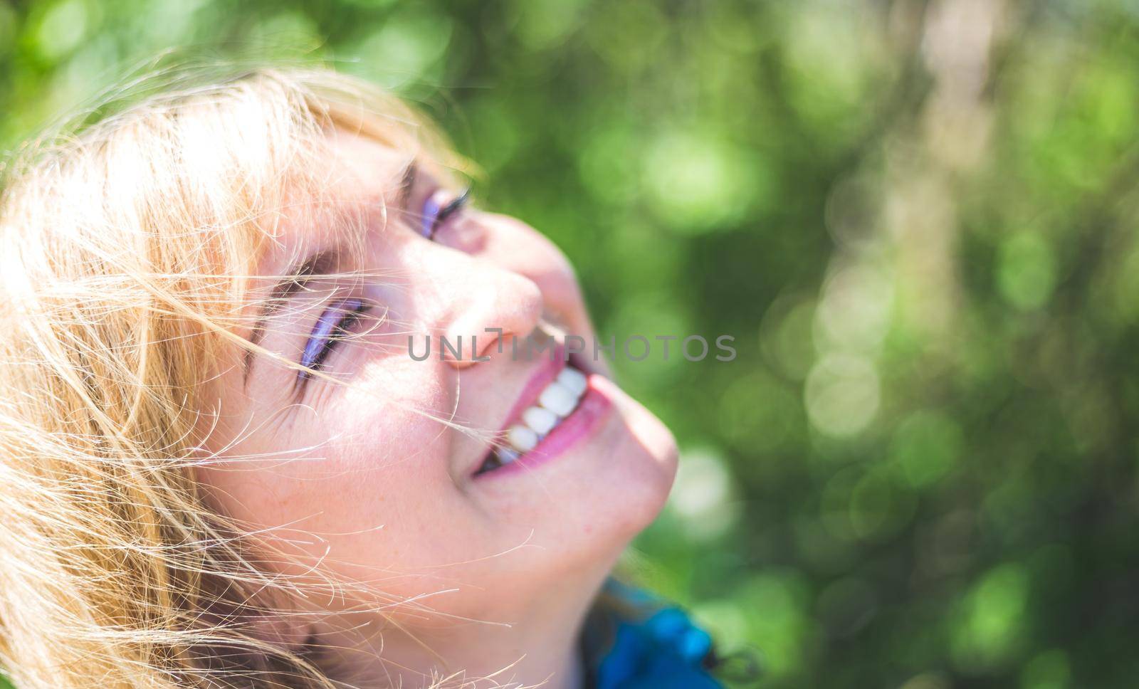 Portrait of attractive young girl outdoors, spring time, blurry green background