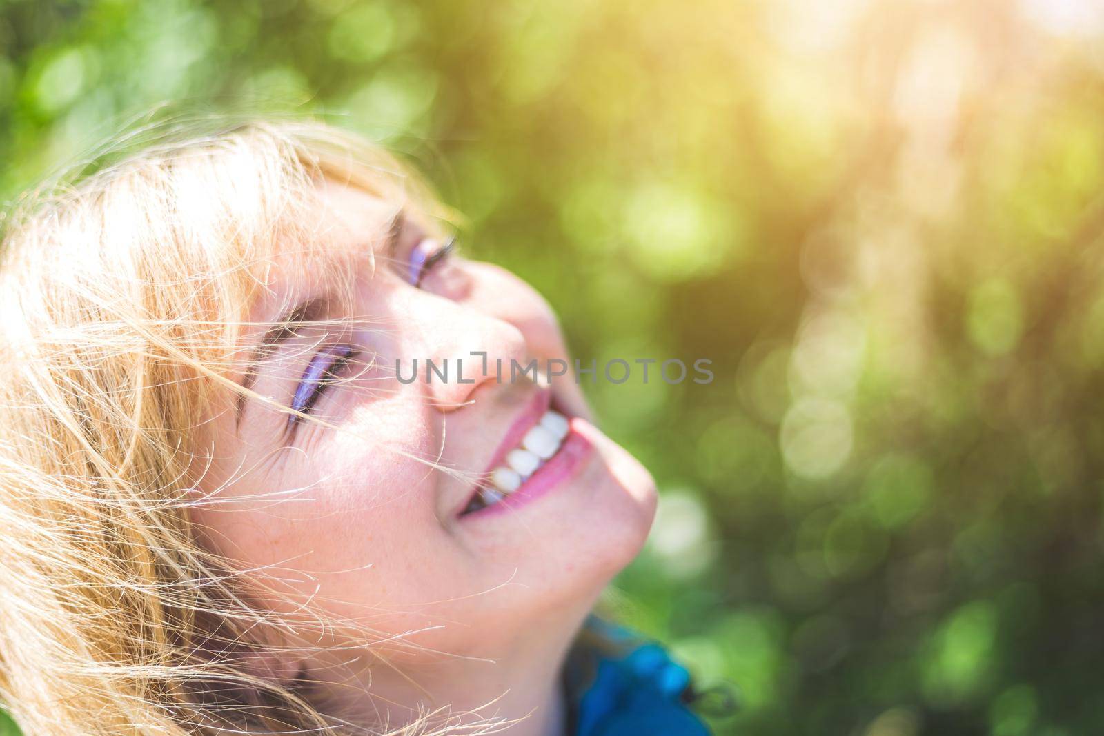 Portrait of attractive young girl outdoors, spring time, blurry green background