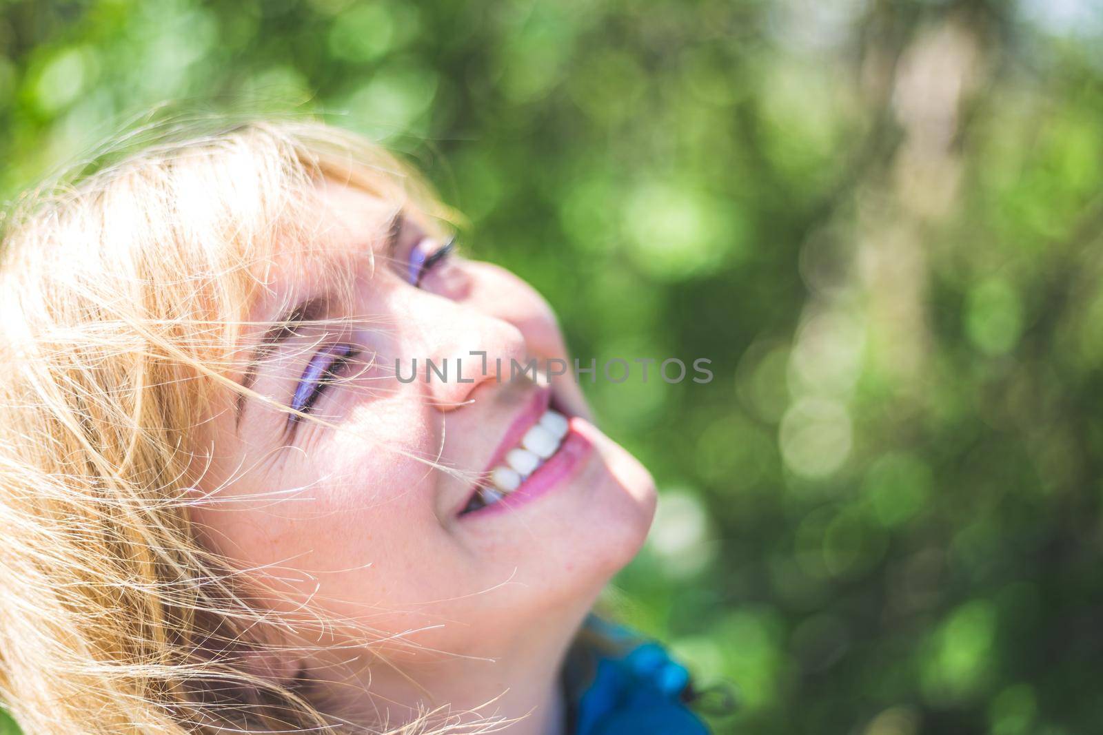 Portrait of attractive young girl outdoors, spring time, blurry green background