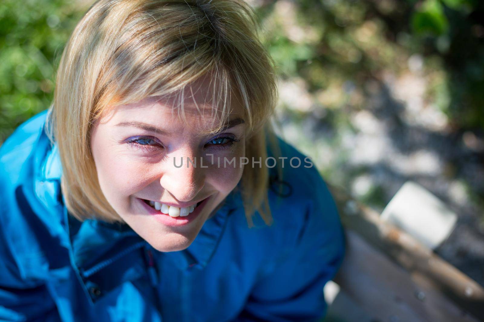 Portrait of attractive young girl outdoors, spring time, blurry green background