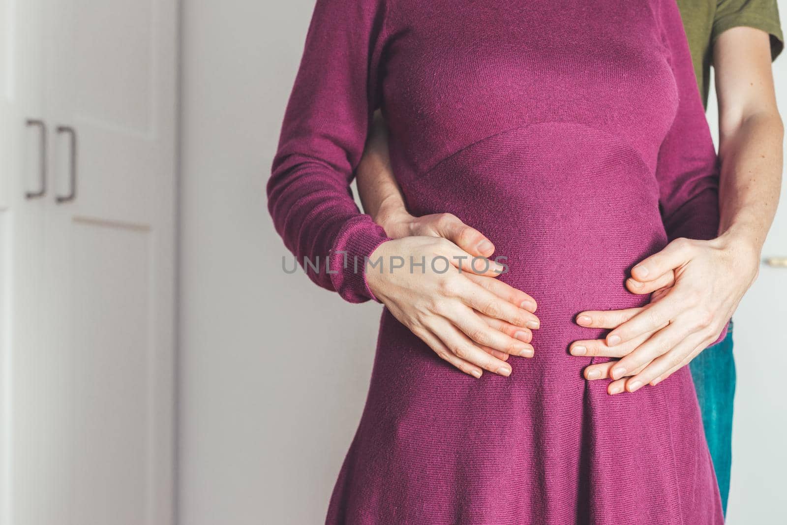 Close up of pregnant mother and father, hugging the tummy, Caucasian