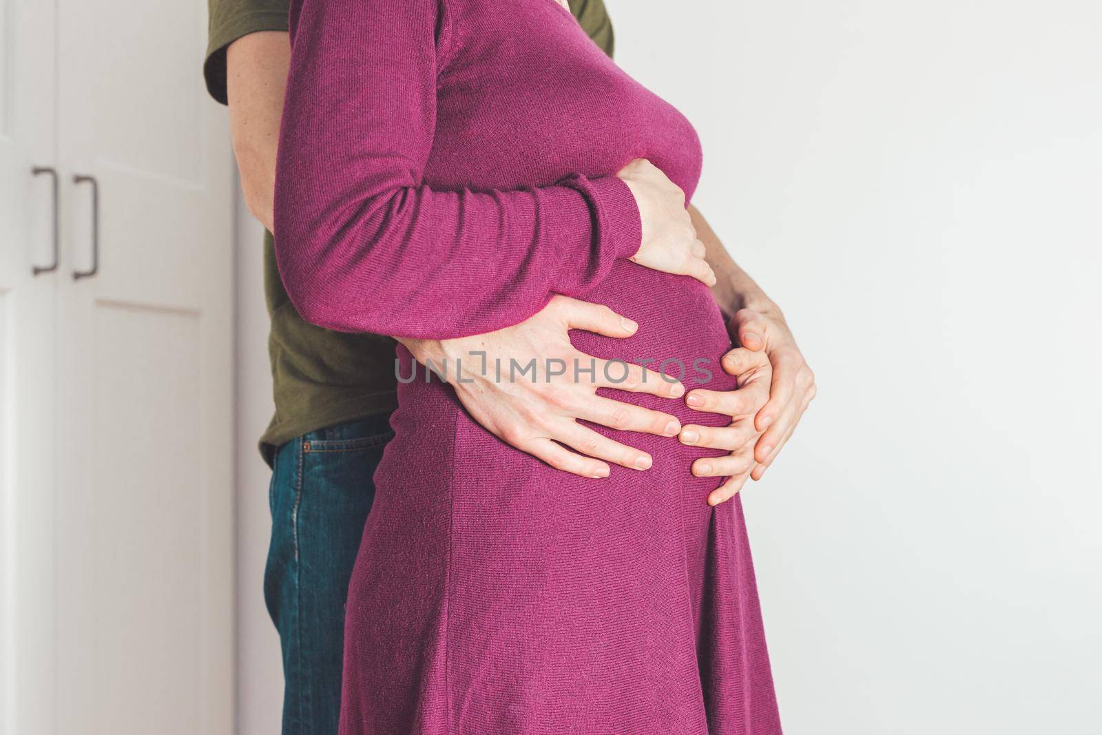 Close up of pregnant mother and father, hugging the tummy, Caucasian