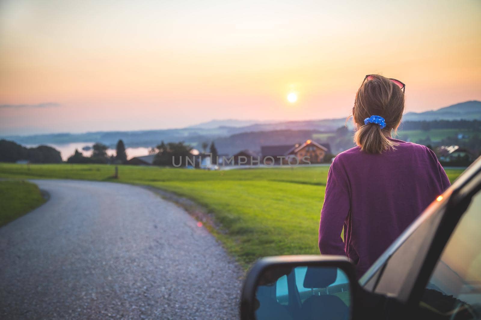 Enjoying the sunset, road trip: Young girl is looking to the horizon by Daxenbichler