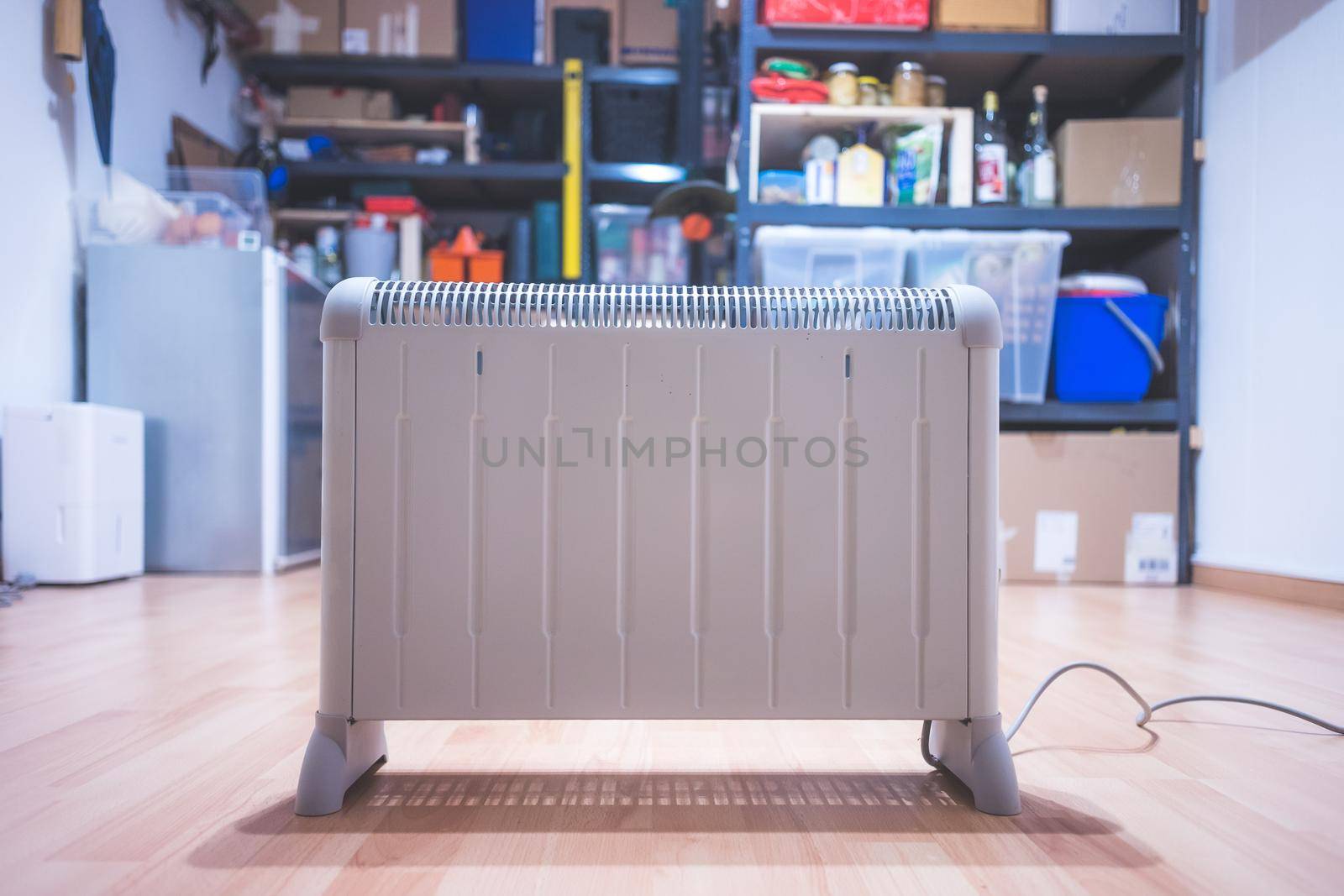 Electric heater, heating the basement. Blurry shelfs in the background