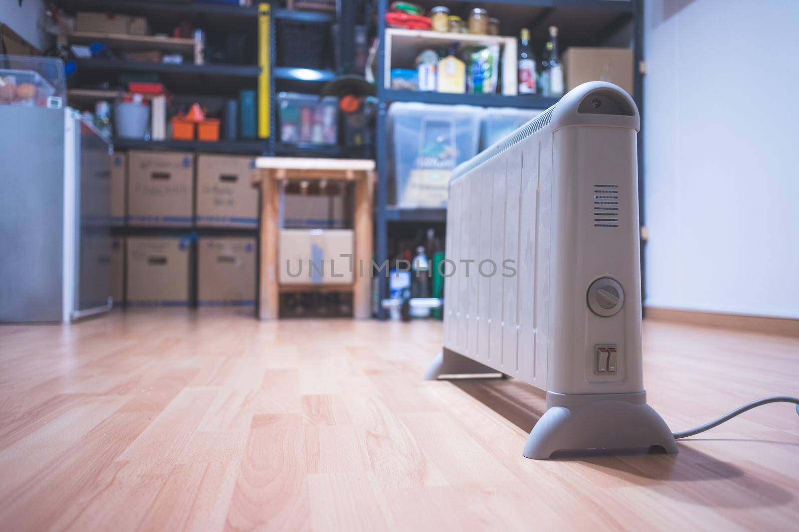 Electric heater, heating the basement. Blurry shelfs in the background