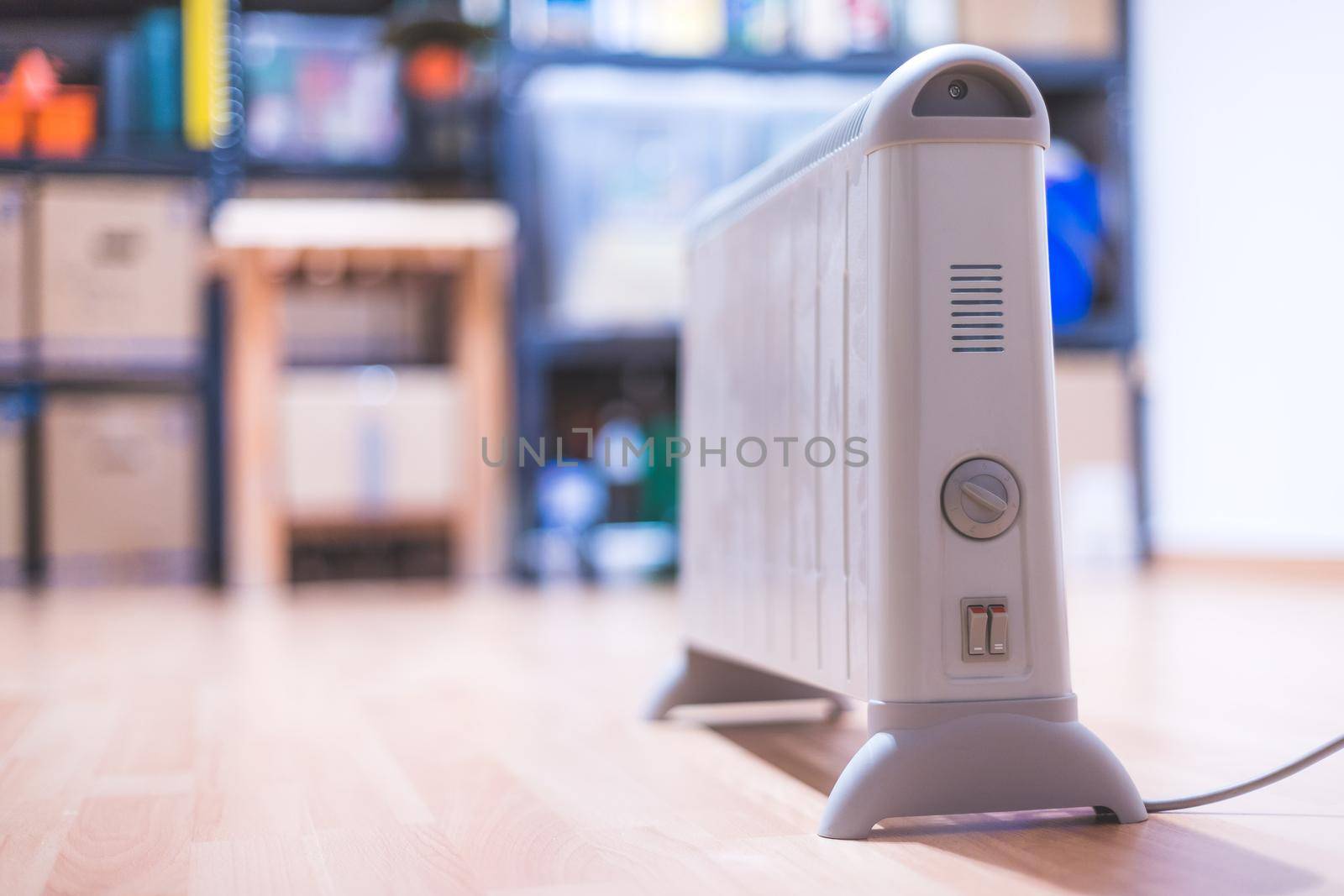 Electric heater, heating the basement. Blurry shelfs in the background